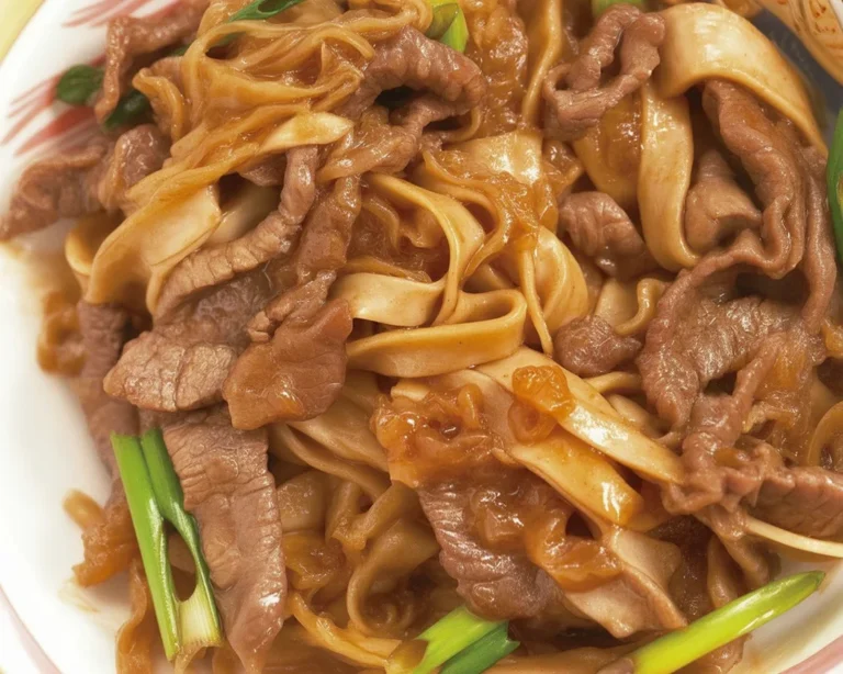 A delicious plate of Beef Chow Fun with tender beef and flat rice noodles served hot.